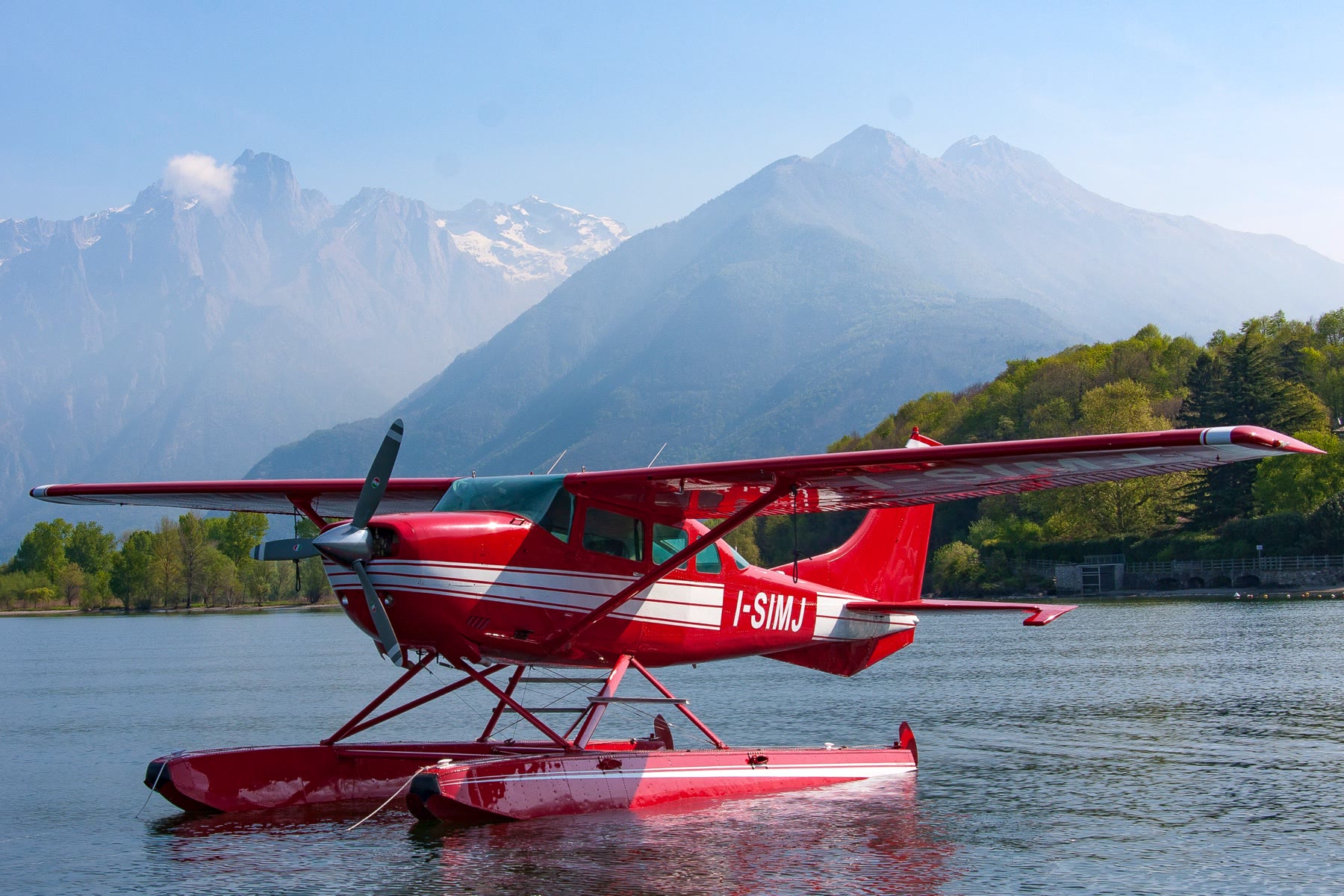 L’idrovolante anfibio rosso e bianco I-SIMJ sull’acqua, con le montagne sullo sfondo